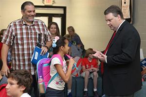 Dr. Ray talking with a student and parent. 